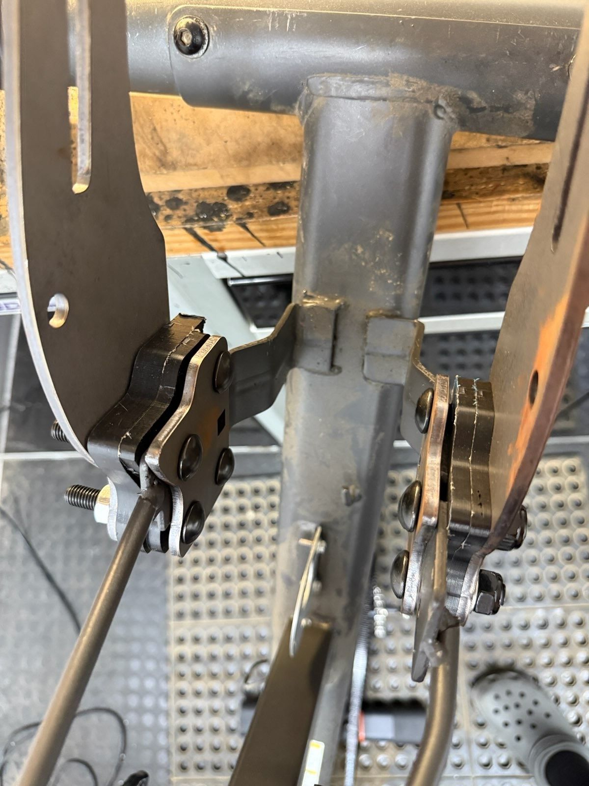 Close view down a gray recumbent frame showing mount spacing and temporary alignment hardware