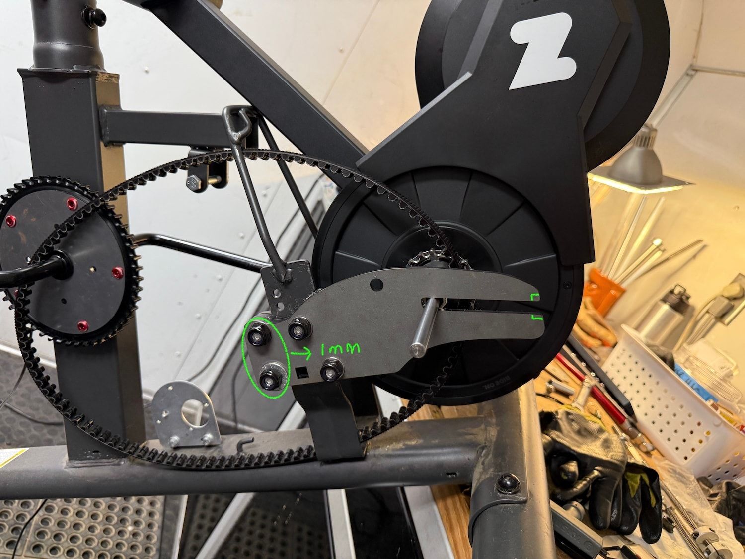 Side view of a Schwinn recumbent with green electronics, black mounting plates, and a toothed belt